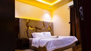 Ein Schlafzimmer mit Bett, Nachttischen und einem einzigartigen Design des Kopfteils.