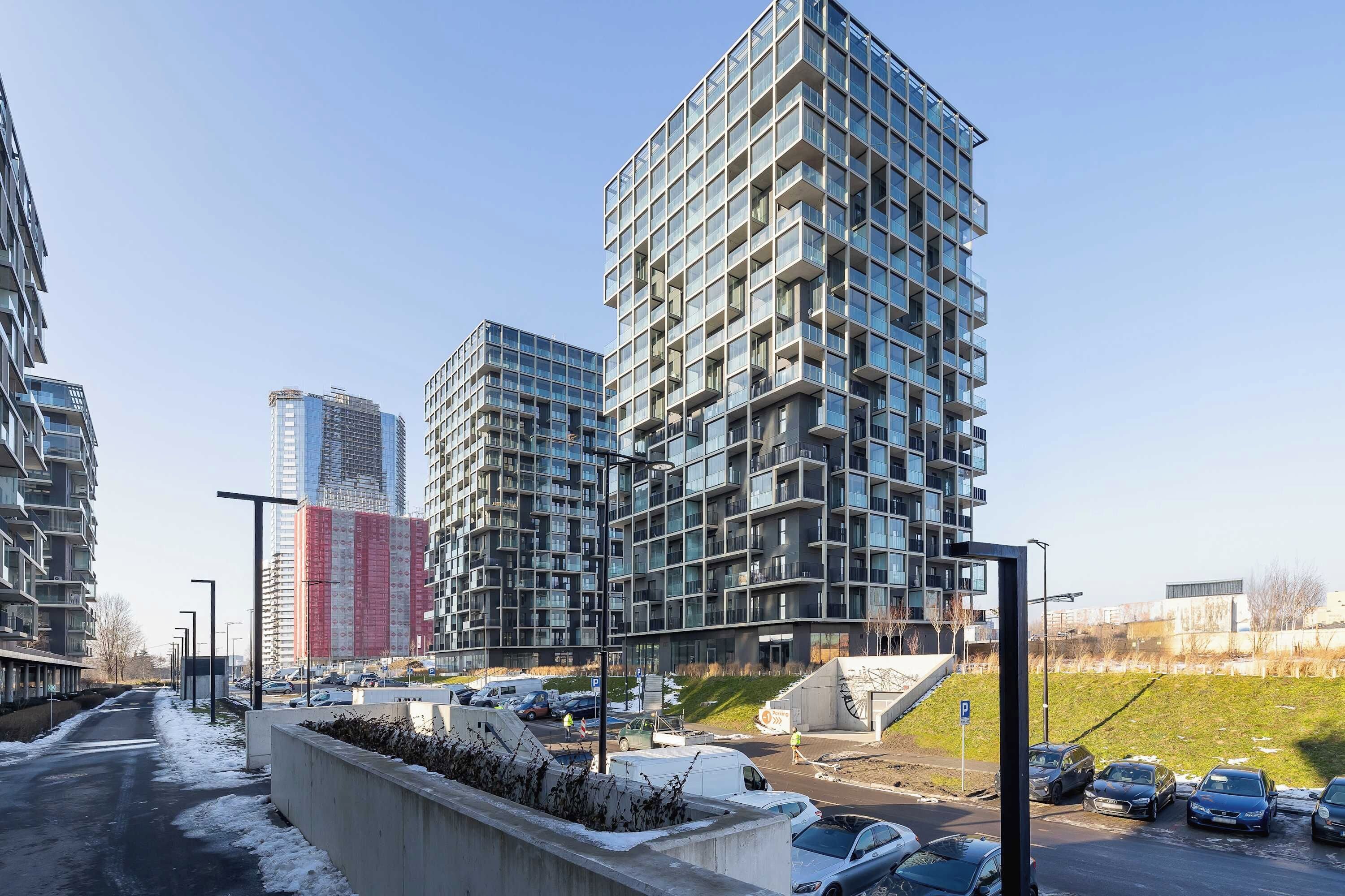 Un edificio moderno de gran altura con fachada de diseño enrejado y balcones.