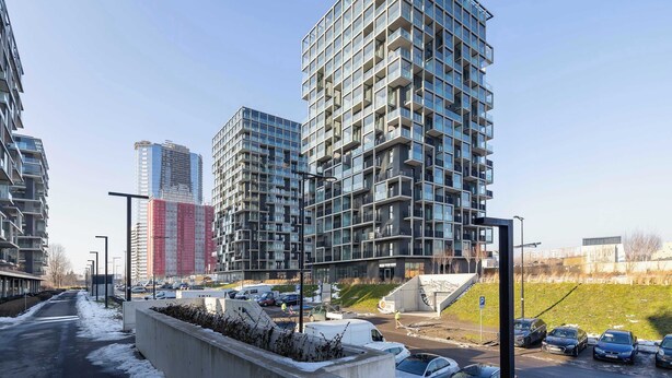 Un edificio moderno de gran altura con fachada de diseño enrejado y balcones.