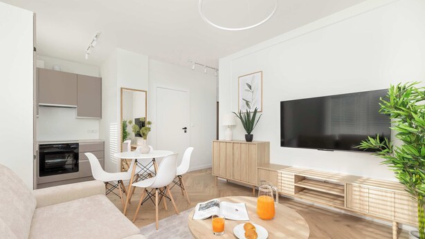 A modern living room with a sofa, dining table, and a TV. There's a kitchen area with cabinets and a microwave.