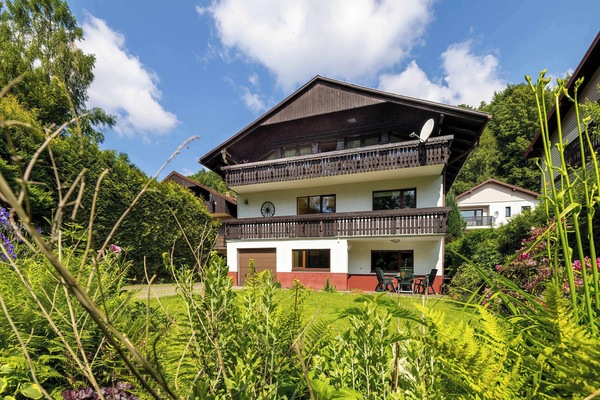 Mountain home exterior with stone steps and lawn – Beautifully kept garden area for nature lovers and outdoor activities.