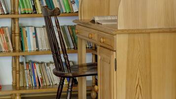 Un bureau en bois avec une chaise, une bibliothèque remplie de livres et un meuble en bois.