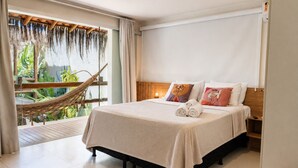A hotel room with a bed, a hammock, a view of greenery, and a balcony. - Pousada Divino Milagre (Passo de Camaragibe)