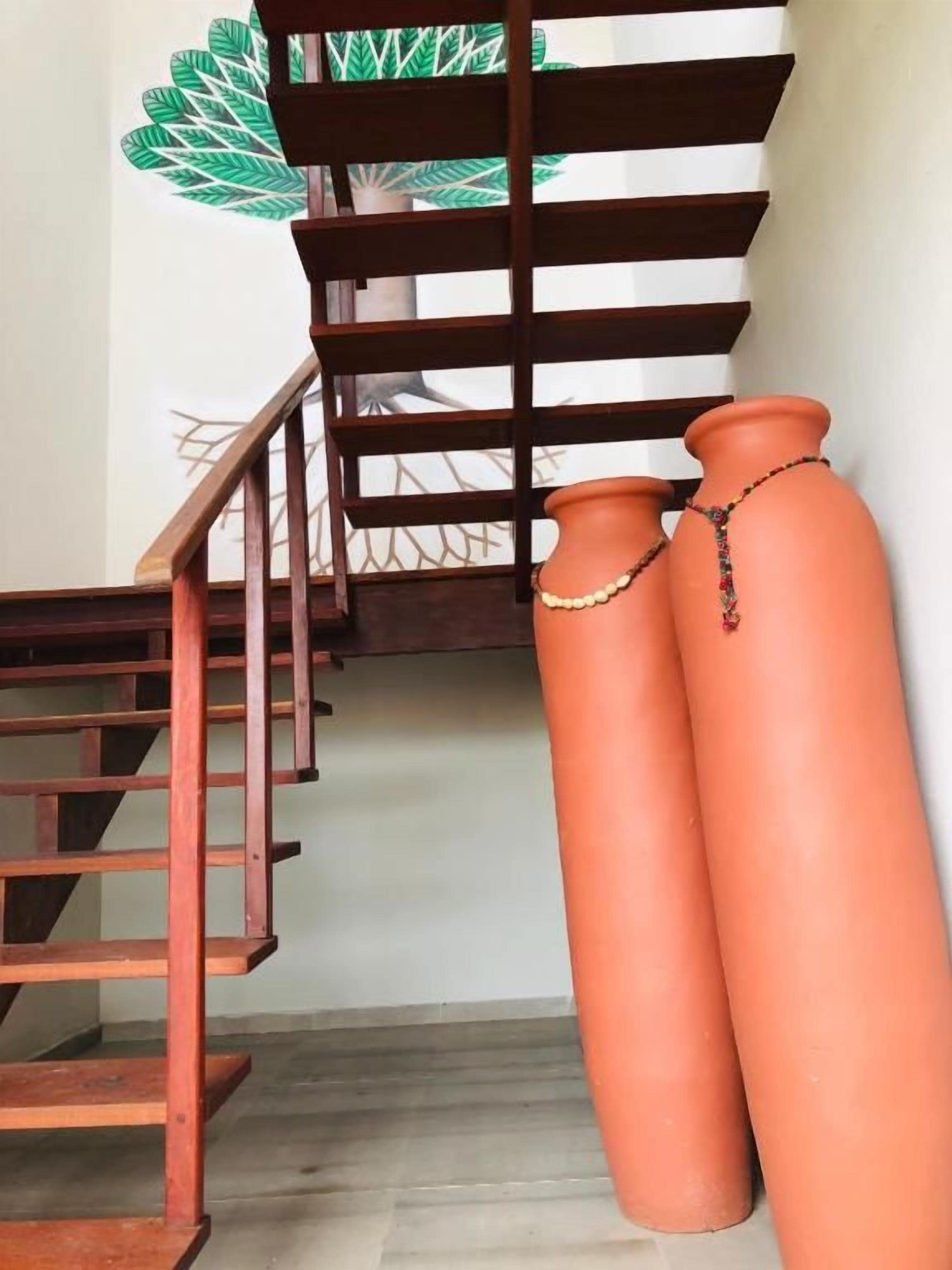 Una escalera con barandillas de madera y macetas de terracota en la parte inferior.