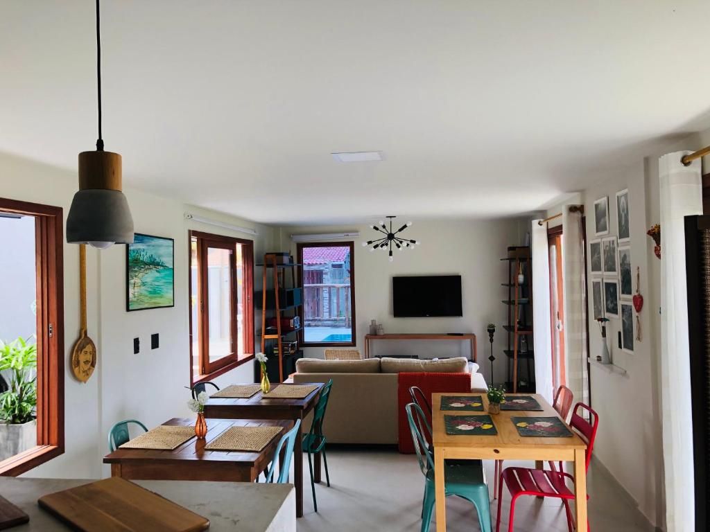 Un espacio habitable moderno con comedor, sofá y televisión montada en la pared.
