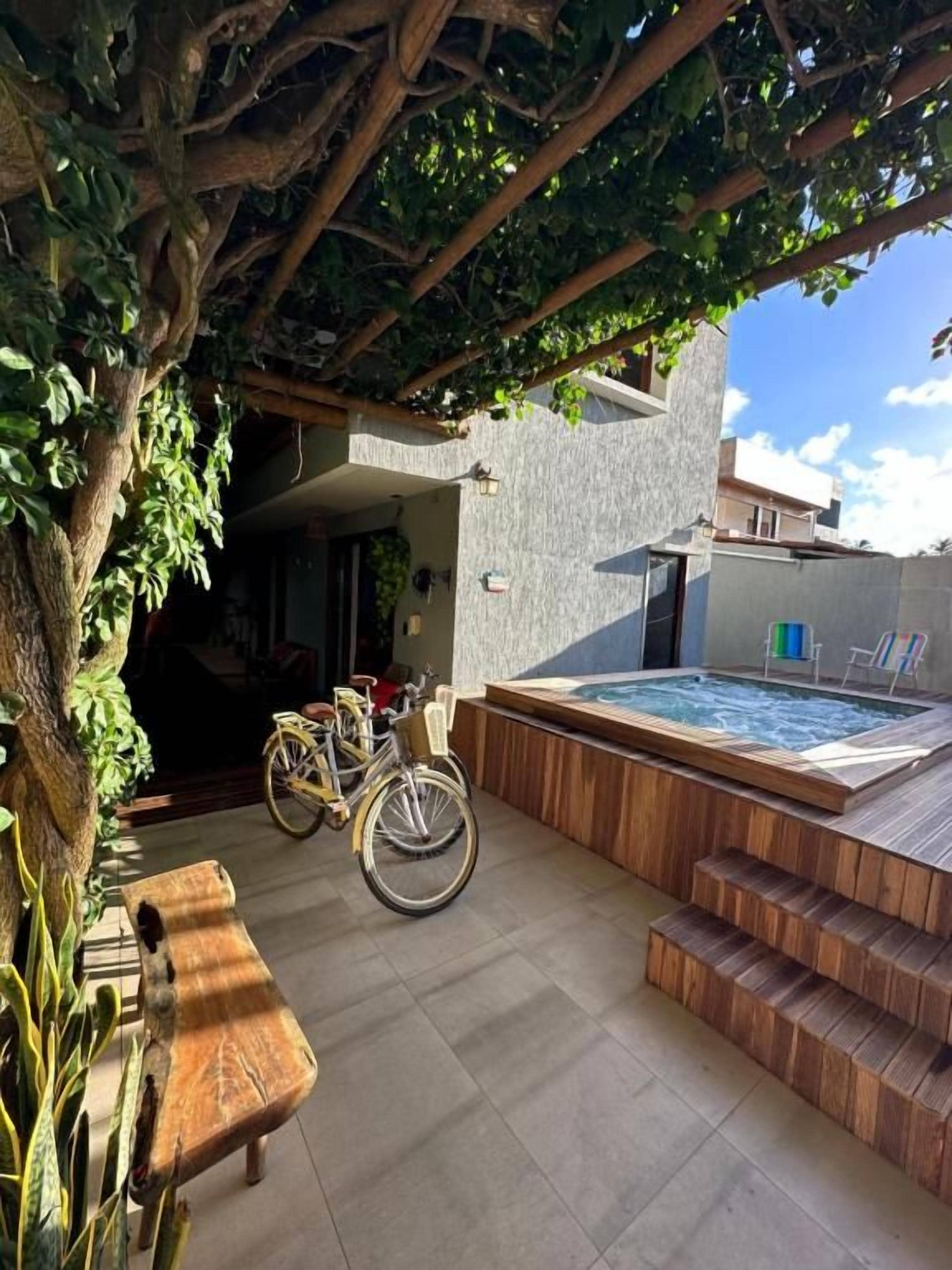 Zona de spa con bañera de hidromasaje, escalones de madera y una bicicleta.
