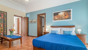 Un dormitorio con una cama grande, una mesita de noche de madera, un escritorio y una silla.