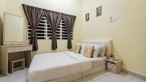 A bedroom with a bed, a bedside table, a mirror, and a window with curtains.