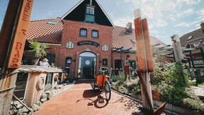 A brick building with a sign reading 'Skippers' Inn' and a bicycle parked in front. - Apartment 'Gorch Fock' with Shared Terrace, Shared Garden and Wi-Fi (Baltrum)