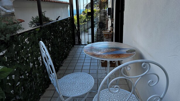 A balcony with a table and two chairs, a view of the sea, and a tiled floor. - Lost in Amalfi, Your home in the heart of a peaceful village on the Amalfi Coast (Amalfi)
