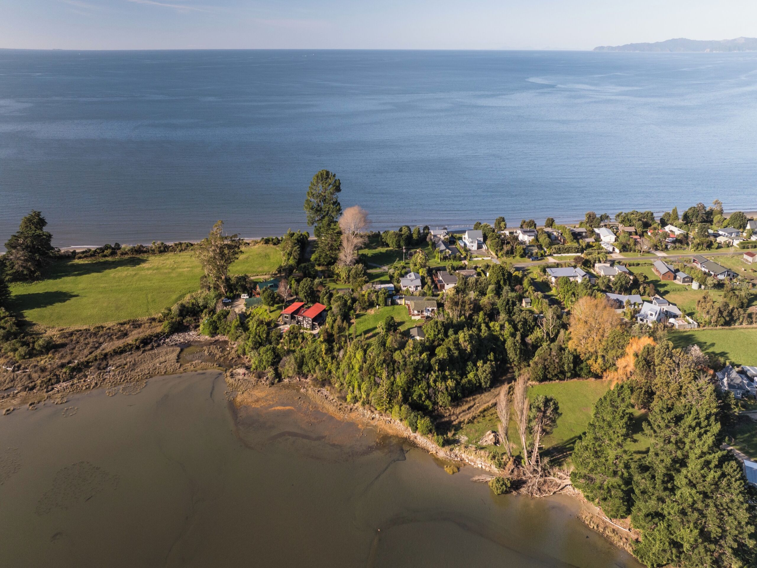 An aerial view of a coastal town with houses, a church, and a lake.