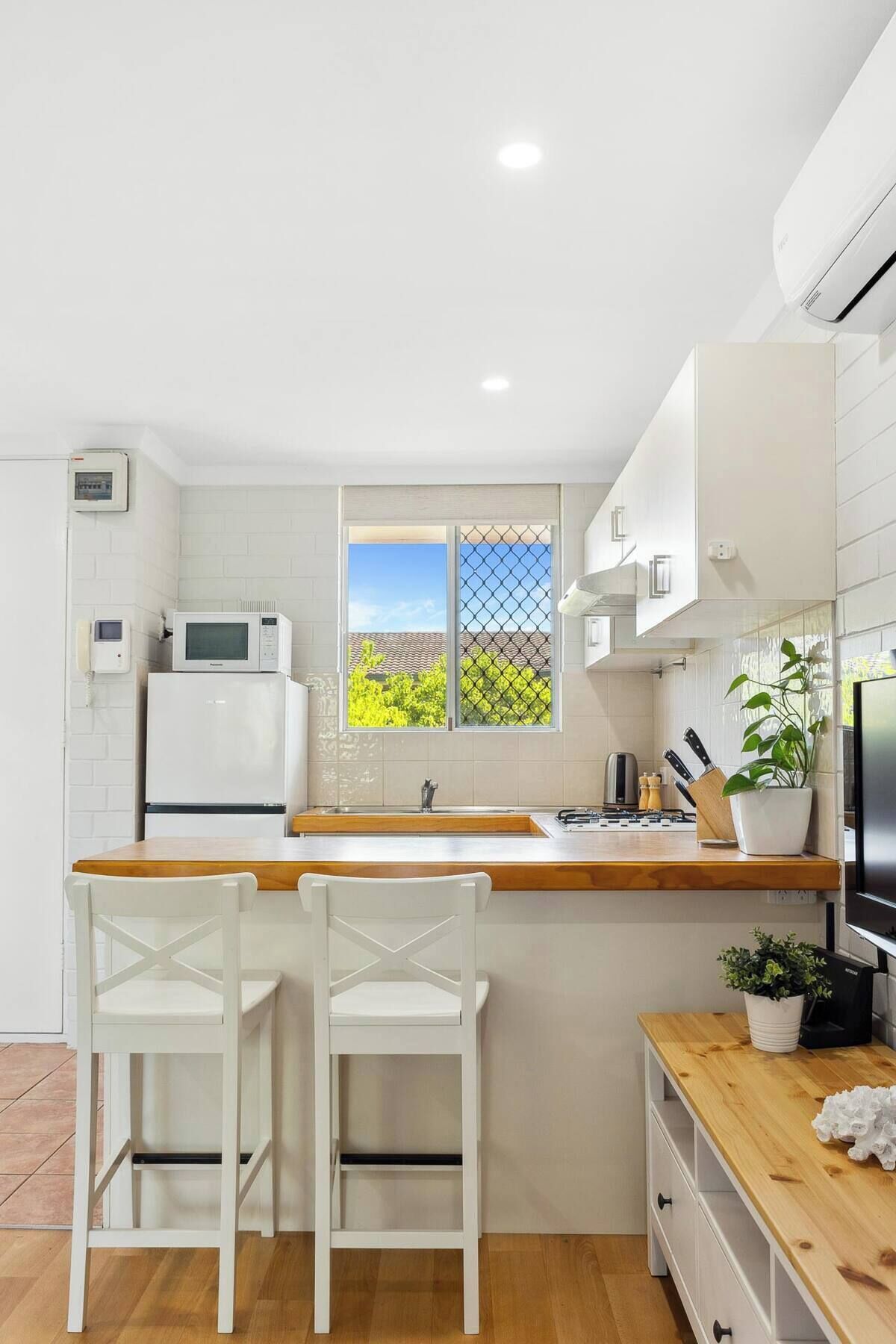 Een koelkast, een oven, een kookplaat, kookgerei, borden en bestek