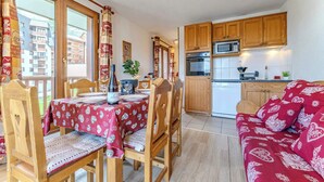 A cozy apartment with a dining area, kitchen, and living room.