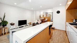 Eine moderne Küche mit weißer Arbeitsplatte, Holzschränken und einem eingebauten Backofen.