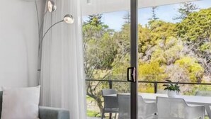 Un soggiorno moderno con un divano, un tavolino da caffè e una zona pranzo con sedie e tavolo.