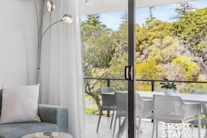 Un soggiorno moderno con un divano, un tavolino da caffè e una zona pranzo con sedie e tavolo.