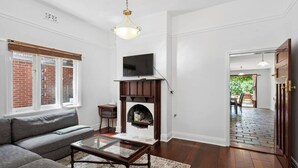 A living room with a fireplace, a sofa, a coffee table, and a television.