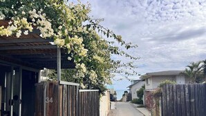 Eine schmale Straße mit einem Holzzaun und einem Gebäude mit Glastür auf der linken Seite.