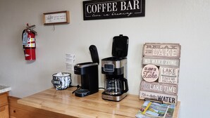 A coffee bar setup with a coffee maker, a basket with a coffee cup, and a fire extinguisher on the wall. - 3-bedroom Cabin at West Wind Resort in beautiful Waskish, MN on Upper Red Lake. (Waskish)