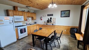 A kitchen with wooden cabinets, a white refrigerator, a stove, a microwave, and a coffee bar. - 3-bedroom Cabin at West Wind Resort in beautiful Waskish, MN on Upper Red Lake. (Waskish)