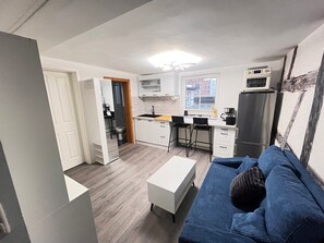 A compact living space with a kitchenette, a dining area, and a sofa. - Apartment '1-Room' with Shared Pool, Shared Garden and Wi-Fi (Erfurt)