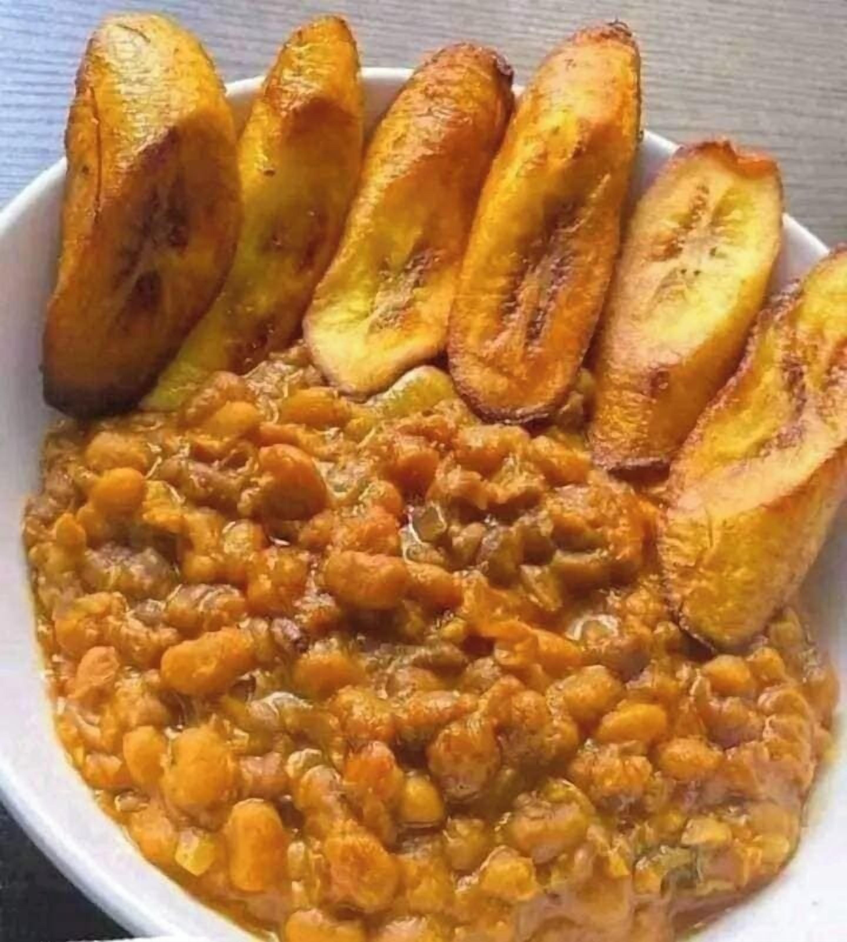 A bowl of lentils with sliced plantains.