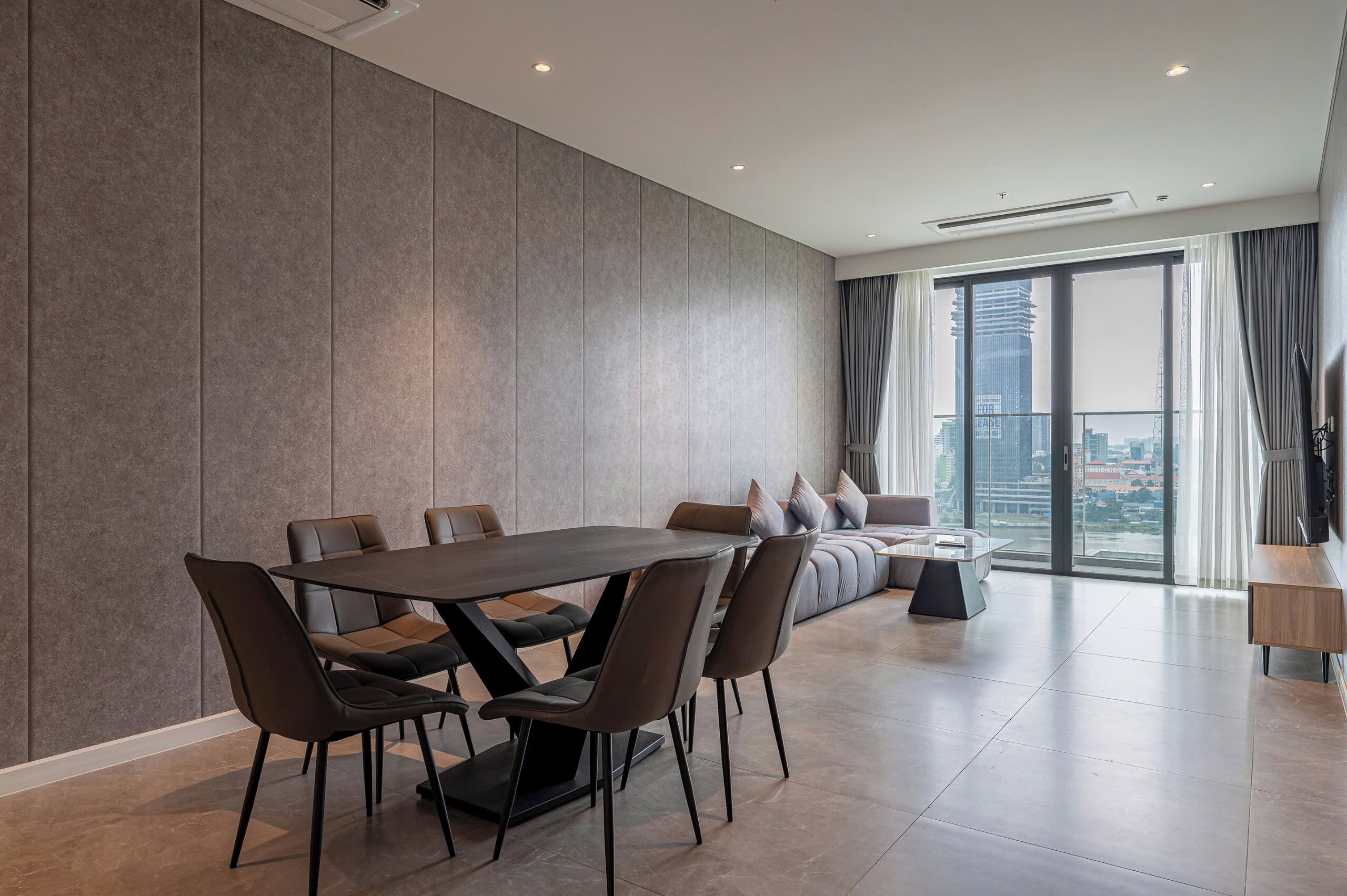 Una sala de estar moderna con comedor, ventanas amplias y vista a la ciudad.