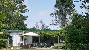 A small, single-story building with a covered patio area. - Cozy Family Home With Lovely Garden (Kamperland)