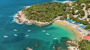 An aerial view of a coastal area with a beach, boats, and a small island with dense vegetation. - Private Pool, Chic, Step’s from beach in beautiful Puerto Escondido - WiFi, AC (Puerto Escondido)