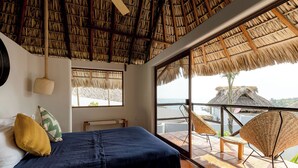A room with a bed, a window, and a balcony with wicker chairs. - Private Pool, Chic, Step’s from beach in beautiful Puerto Escondido - WiFi, AC (Puerto Escondido)