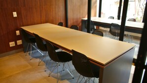 Una sala de conferencias con una larga mesa y cuatro sillas.
