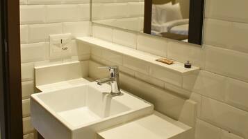 Une salle de bain avec deux lavabos, un miroir et un distributeur de serviettes.