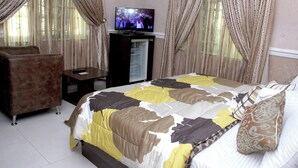 Une chambre à coucher avec un lit, une télévision, un bureau et une chaise.