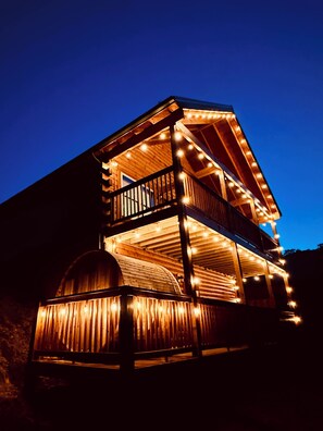 Ein mehrstöckiges Holzgebäude mit Balkonen und Lichterketten.