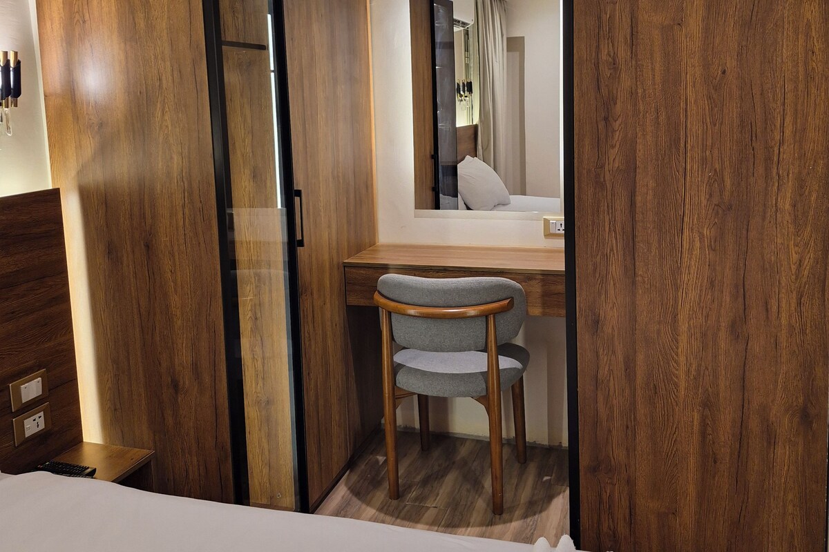 Ein Hotelzimmer mit einem Bett, einem Schreibtisch, einem Stuhl und einem Kleiderschrank.