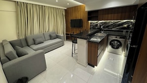 Suite Deluxe, balcón, vista a la ciudad | Área de sala de estar