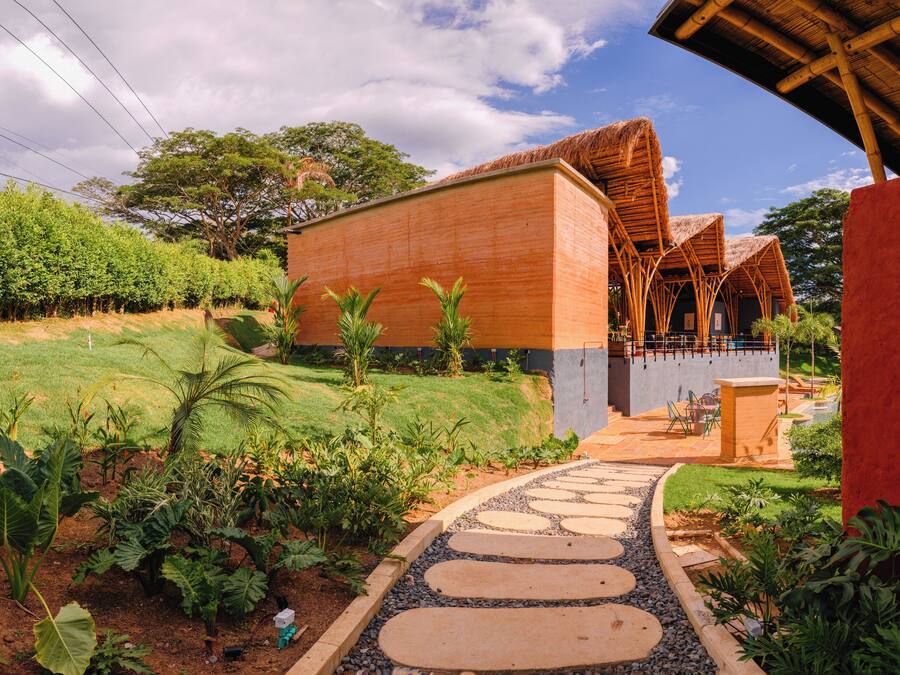 A modern building with a wooden facade and a thatched roof structure.