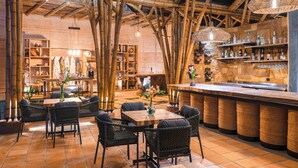 Ein Restaurant mit Bambusbalken, Korbmöbeln und einer Bar.