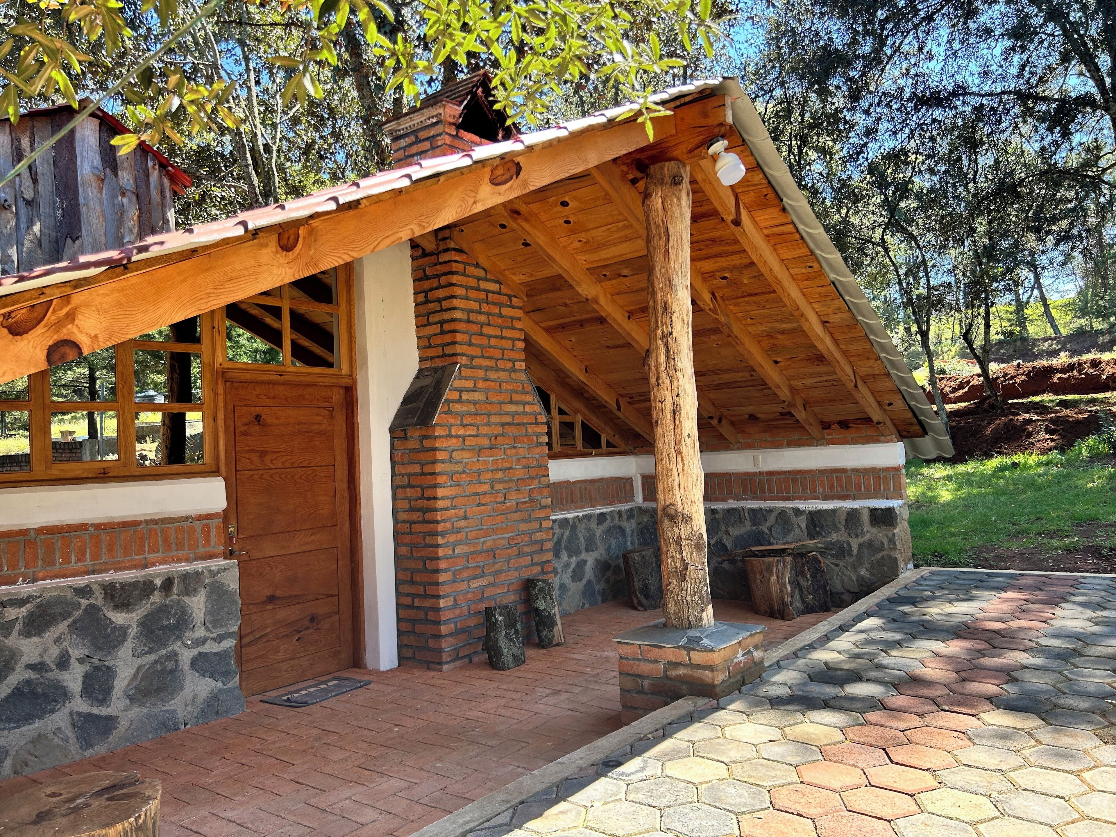A rustic cabin with a stone foundation, wooden beams, and a sloped roof.