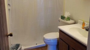 A bathroom with a toilet, a sink, and a shower curtain.