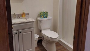 Ein Badezimmer mit Toilette, einem Waschbecken mit Marmorplatte und einem Mülleimer.