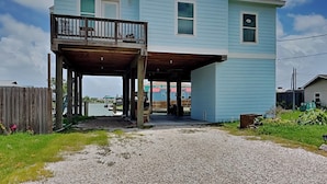 A two-story house with a covered porch and a small balcony. - T's Getaway by Miss Kitty’s (Rockport)