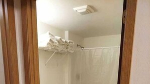 A bathroom with a toilet, a shower, and a wooden floor. - Deluxe 2 Bedrooms 8 XL Twin Beds, 2 Bathrooms Ground Floor #7 (Devils Lake)