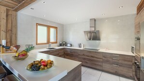 Una cocina moderna con armarios de madera, una isla central y una campana extractora de acero inoxidable.