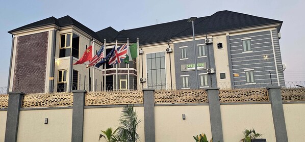 A building with multiple flags, including the Chinese, American, and British flags, and a sign that reads "GREENVIEW."