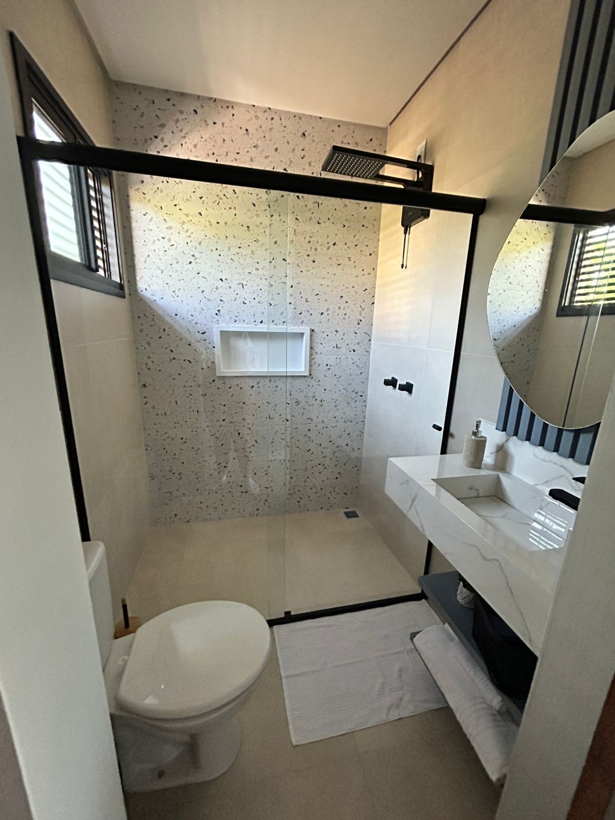 Une petite salle de bain comprenant des toilettes, un lavabo et un espace douche.