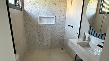 Une petite salle de bain comprenant des toilettes, un lavabo et un espace douche.