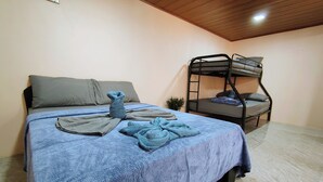 Um quarto com uma cama, uma beliche e uma pequena planta.