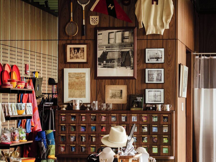 Una stanza con una parete in legno, diversi oggetti da collezione, un tavolo con libri e un cappello.