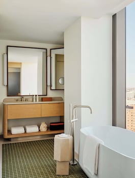 A marble table with a vase of flowers, a red pen, a hotel name card, and a do not disturb sign. at The Atlas Hotel